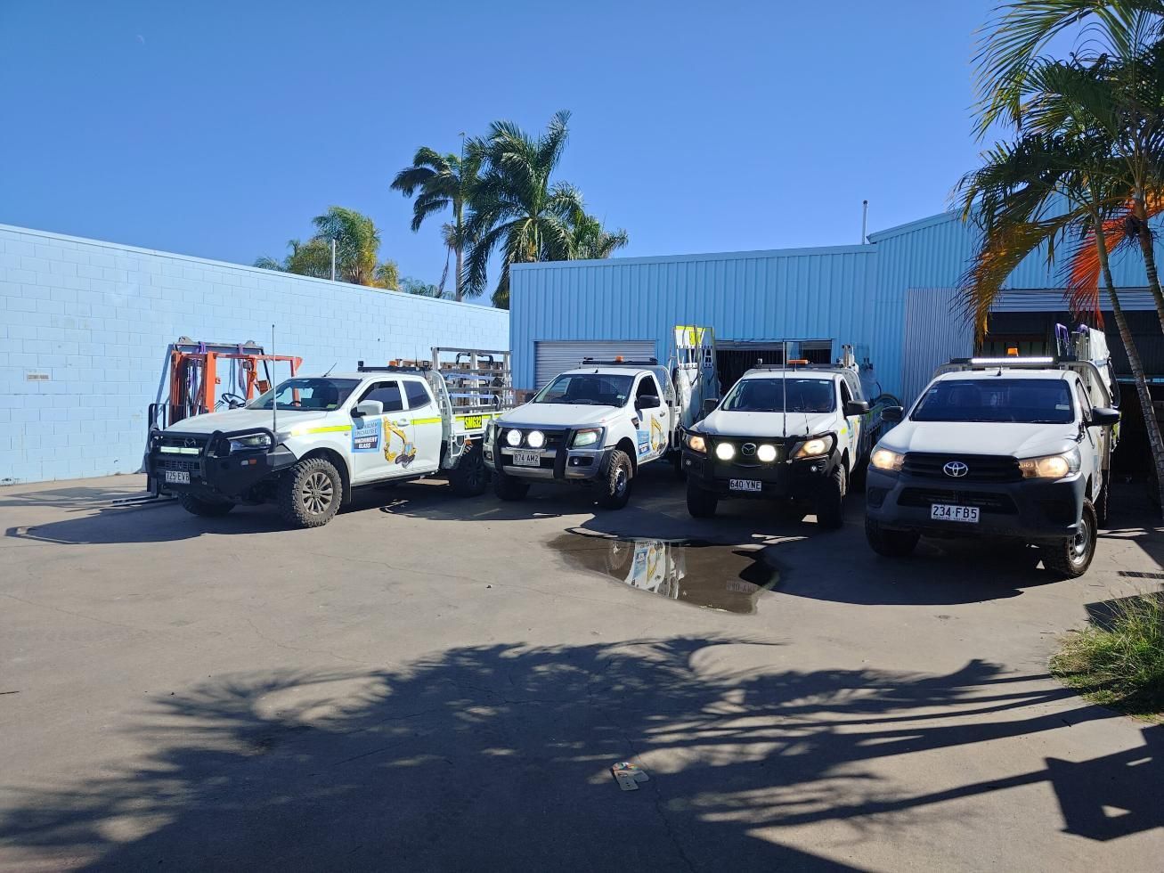 A Row Of Trucks Are Parked In Front Of A Building  — Australian Specialised Machinery Glass In Blackwater, QLD