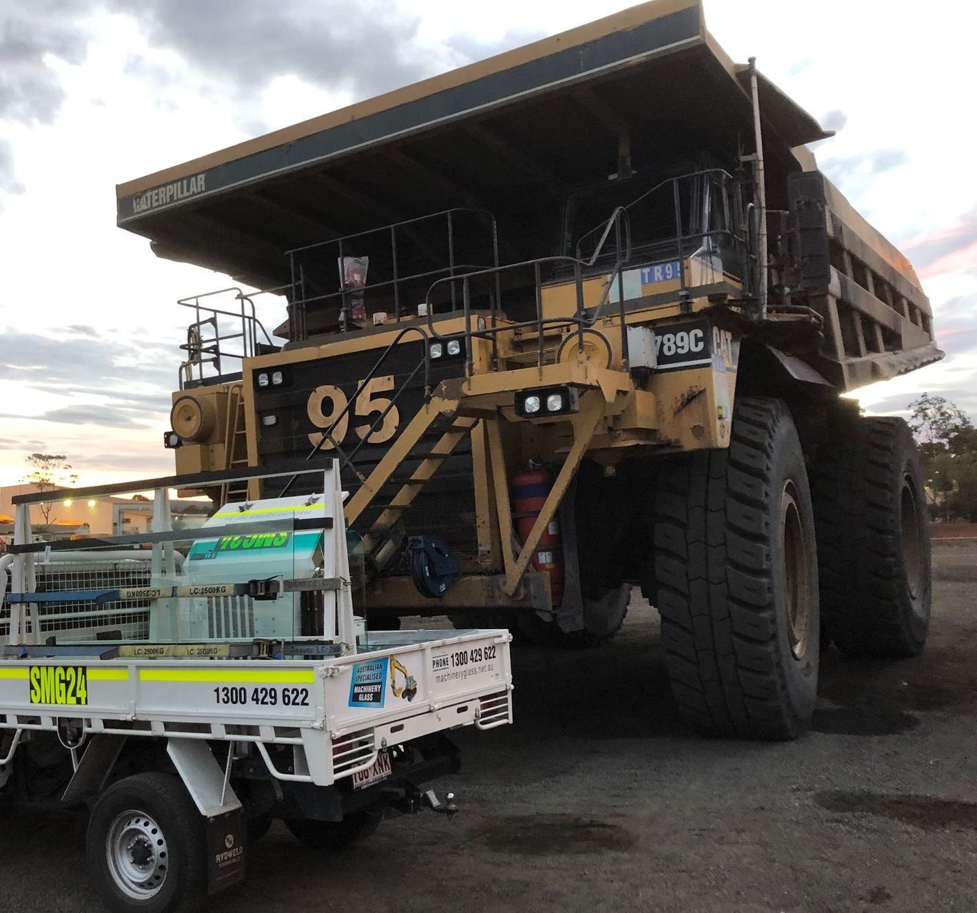 A Bulldozer Is Parked Next To A Van In A Field — Australian Specialised Machinery Glass In Mount Louisa, QLD