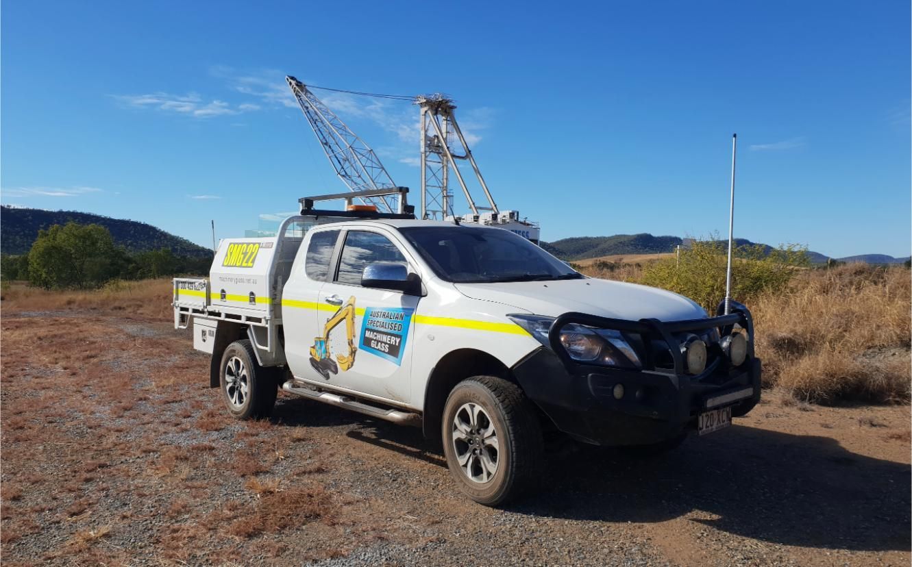 A White Truck With A Crane On Top Of It Is Parked In A Dirt Field — Australian Specialised Machinery Glass In Blackwater, QLD