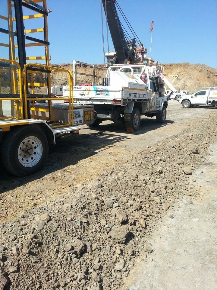A Truck With A Crane On The Back Is Parked On A Dirt Road — Australian Specialised Machinery Glass In Mackay, QLD