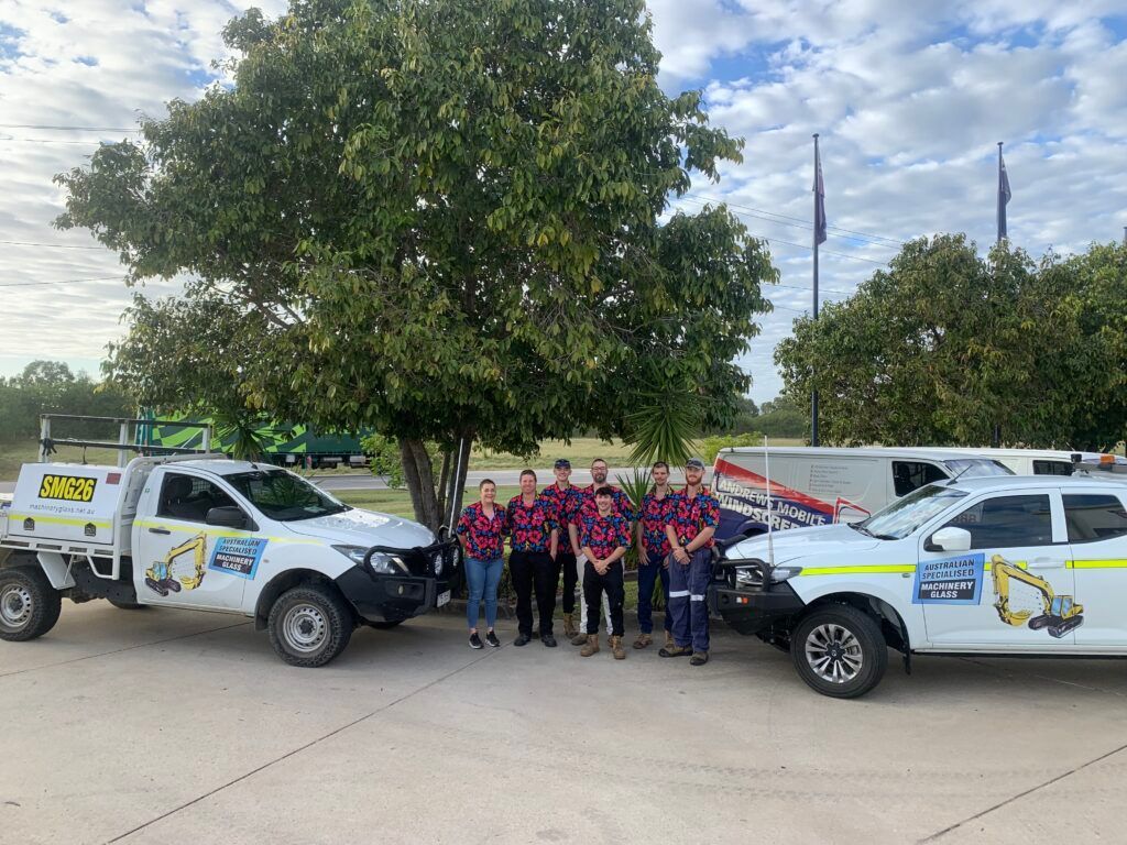 A Group Of People Are Posing For A Picture In Front Of Trucks  — Australian Specialised Machinery Glass In Blackwater, QLD