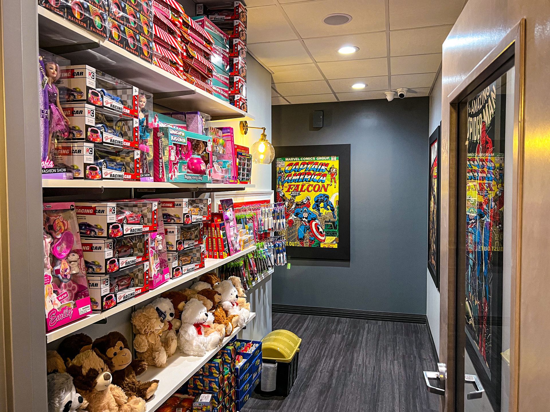 Toy-filled store aisle with shelves of colorful plush animals and candy, leading to a bright poster at the end.