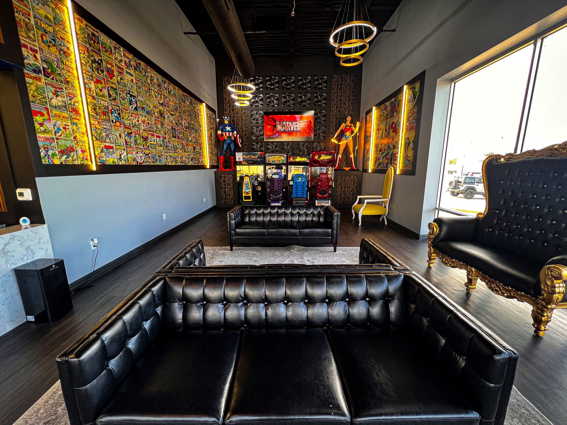 Stylish lounge with black leather seating, colorful wall art, and large windows overlooking a city view