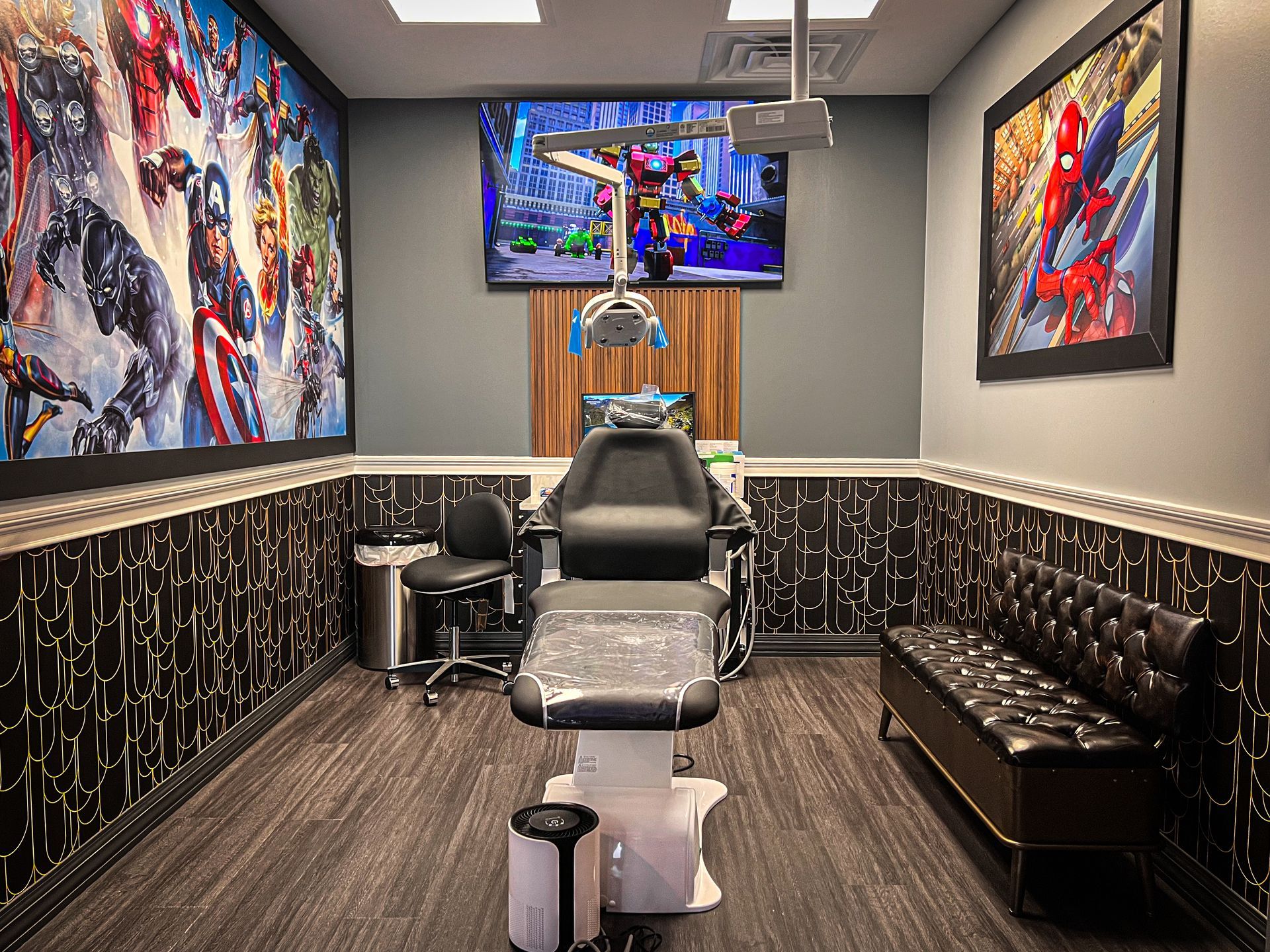 Modern tattoo studio with a central chair, framed art on gray walls, and a black leather bench