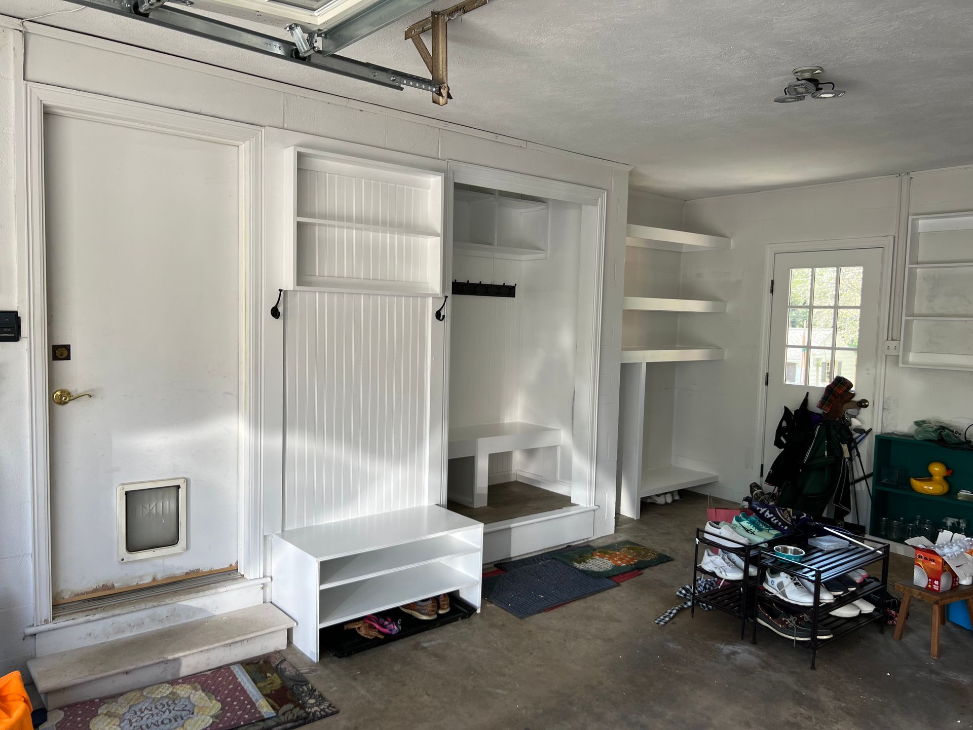 White wooden custom built cabinets in large two car garage by Harkin Construction