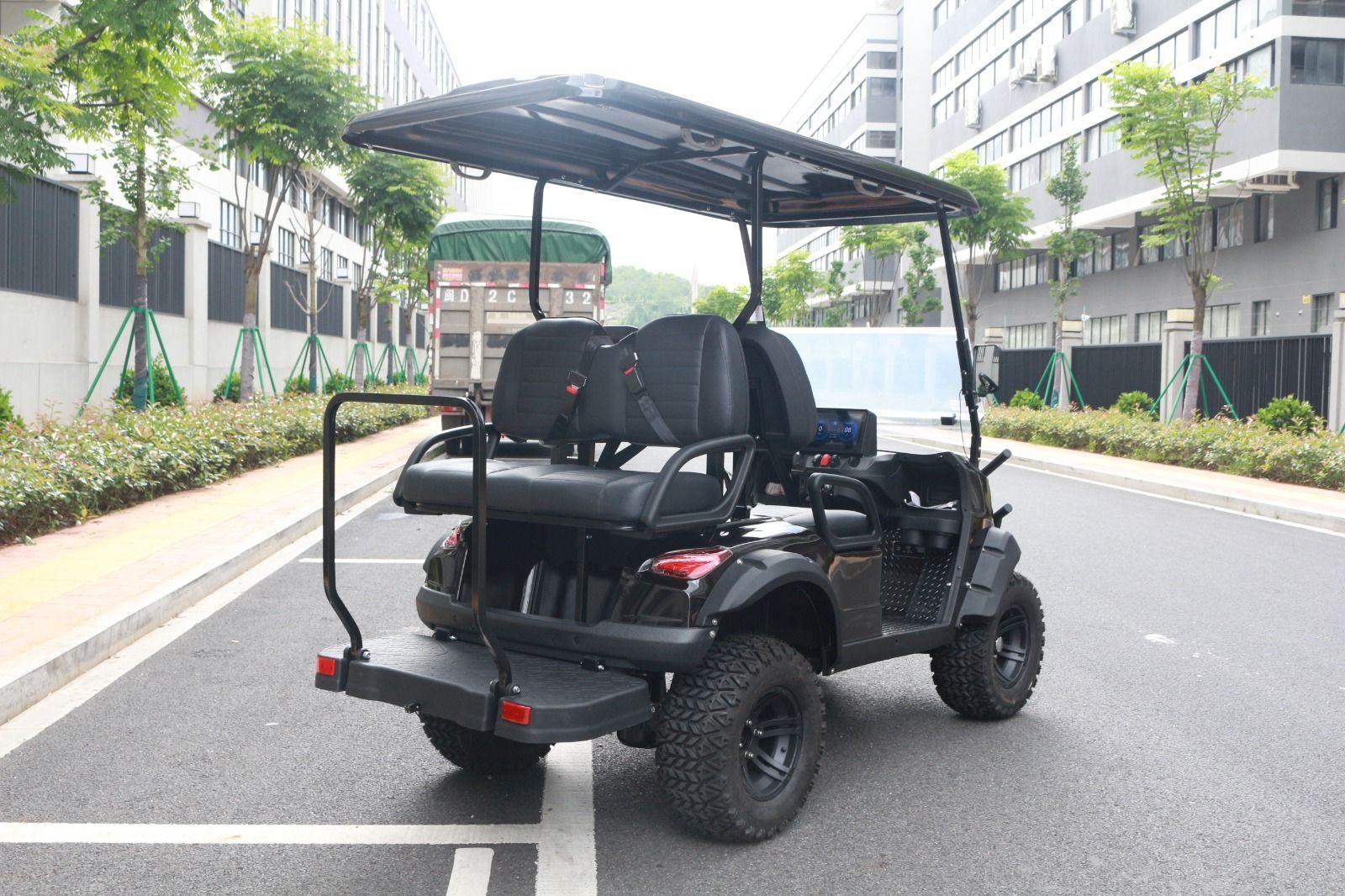 Carrito de golf negro en una carretera asfaltada, neumáticos negros, techo negro, dos filas de asientos
