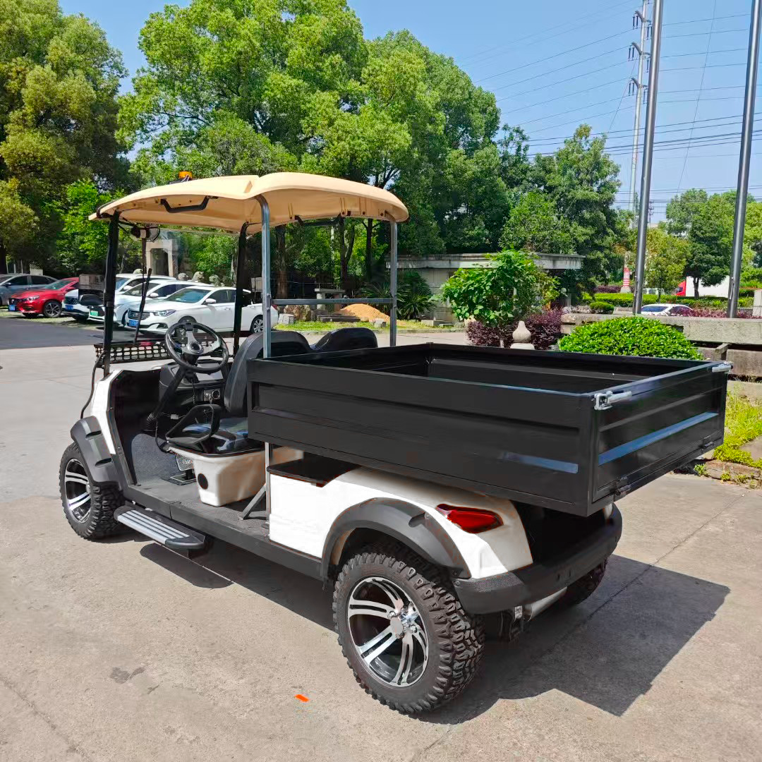Carrito de golf utilitario blanco y negro con caja de carga negra estacionado en el pavimento.