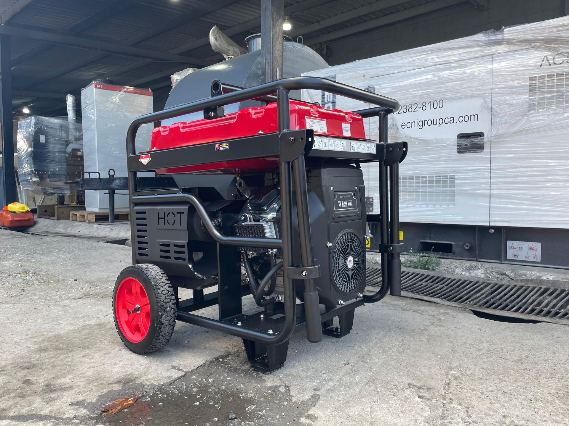 Generador portátil rojo y negro con jaula protectora y ruedas rojas