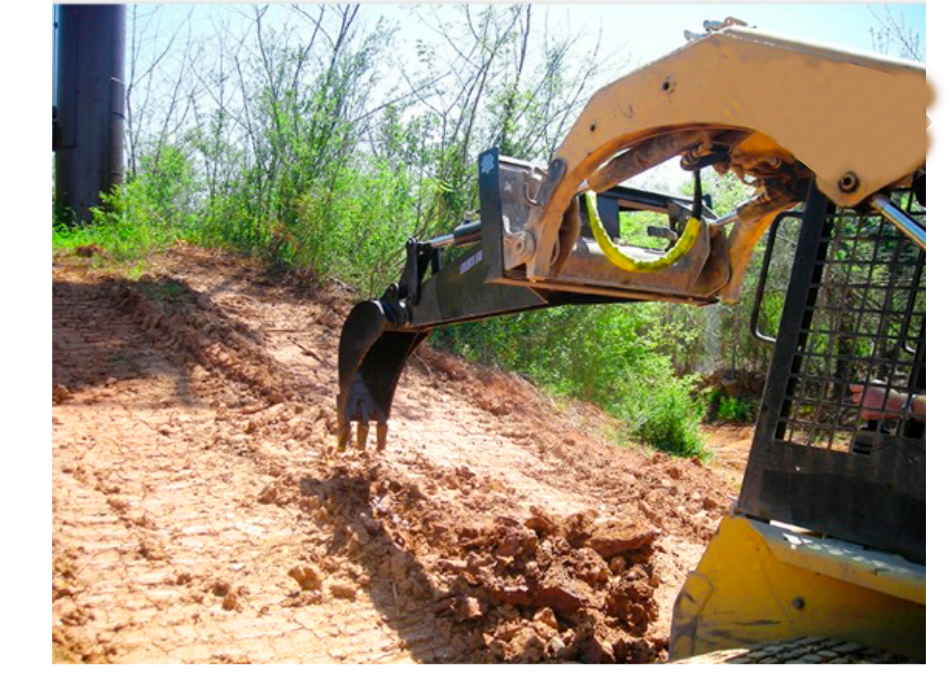 Minicargadora amarilla excavando en una ladera fangosa.