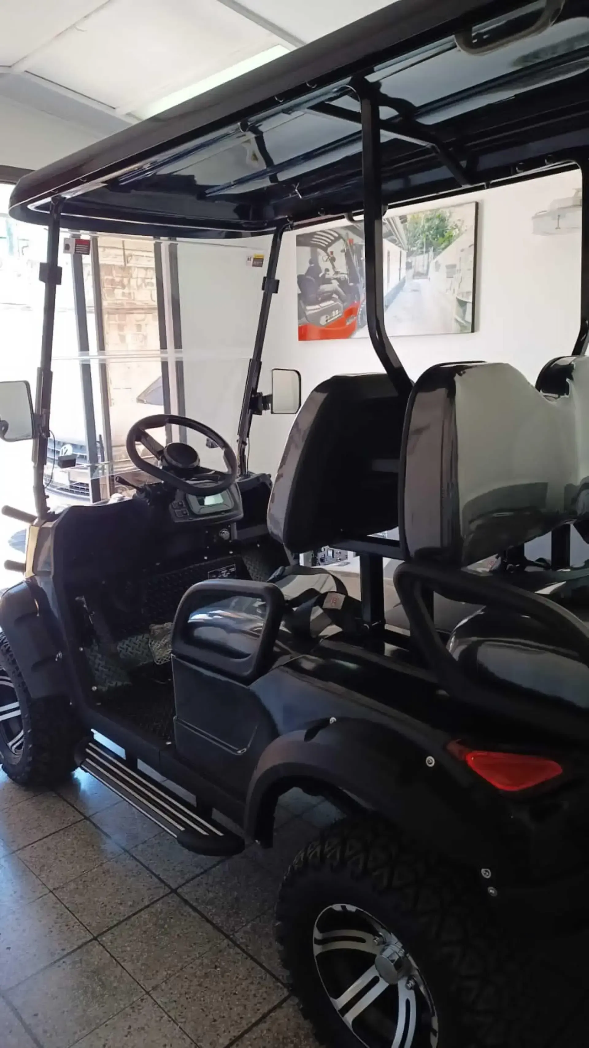Un carrito de golf negro está estacionado en un garaje.