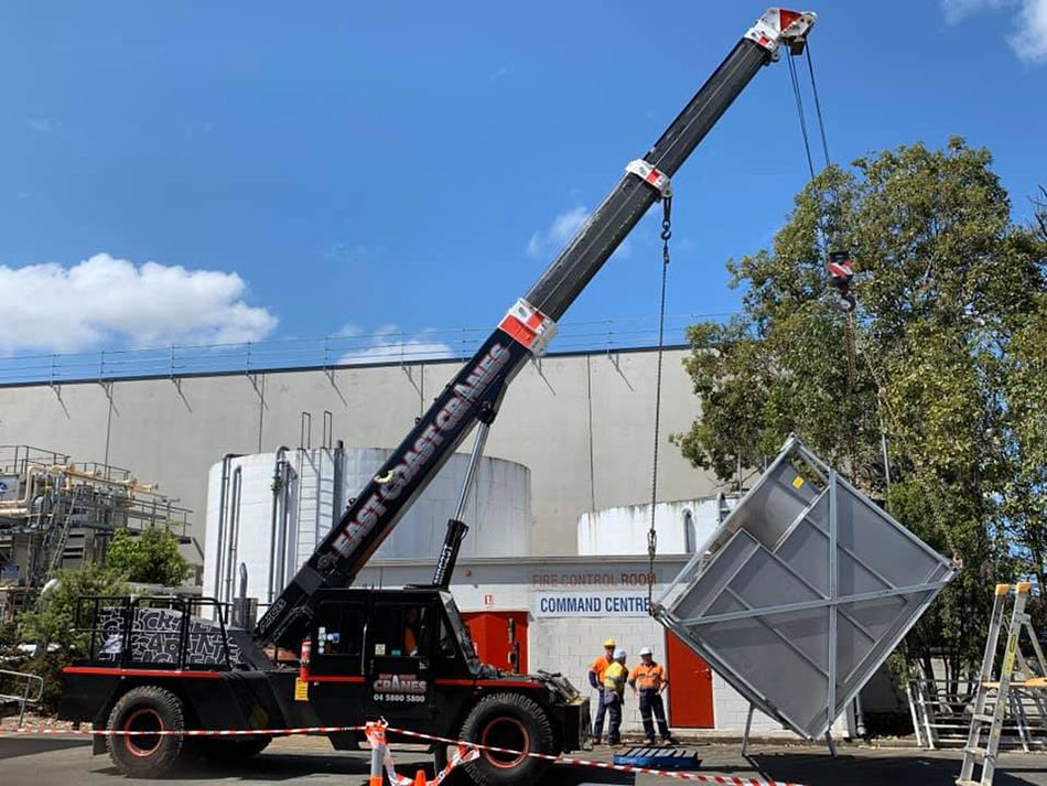 A Large Crane is Lifting a Large Piece of Metal — East Coast Cranes in Newcastle, NSW