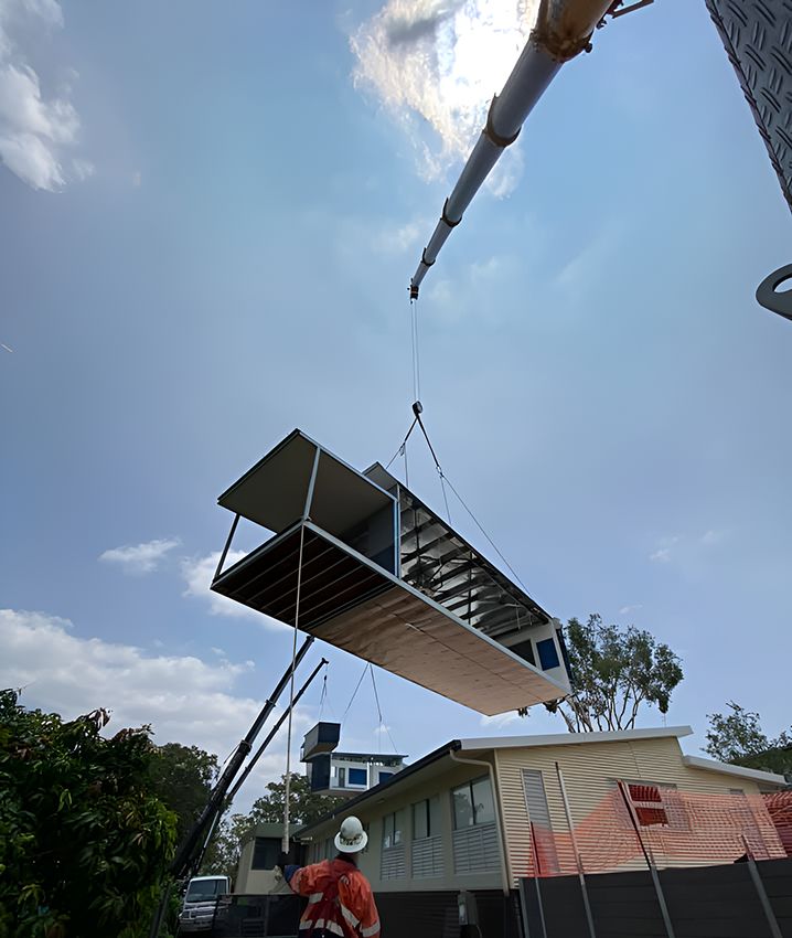 A Crane is Lifting a House Into the Air — East Coast Cranes in Ormeau, QLD