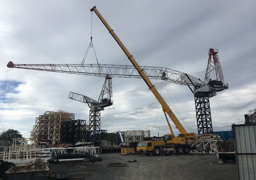 A Yellow Crane Lifting a Metal Boom to Be Placed on Two Tower Crane — East Coast Cranes in Ormeau, QLD