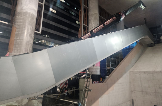 Partially Constructed Escalator in a Concrete Building With Gray Panels, a Dark Sign, and Scaffolding — East Coast Cranes in Ormeau, QLD