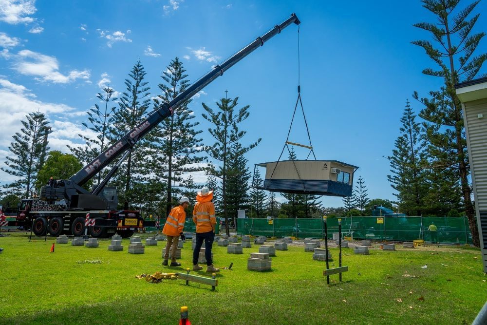 A Crane Is Lifting a House Into the Air — East Coast Cranes in Ormeau, QLD