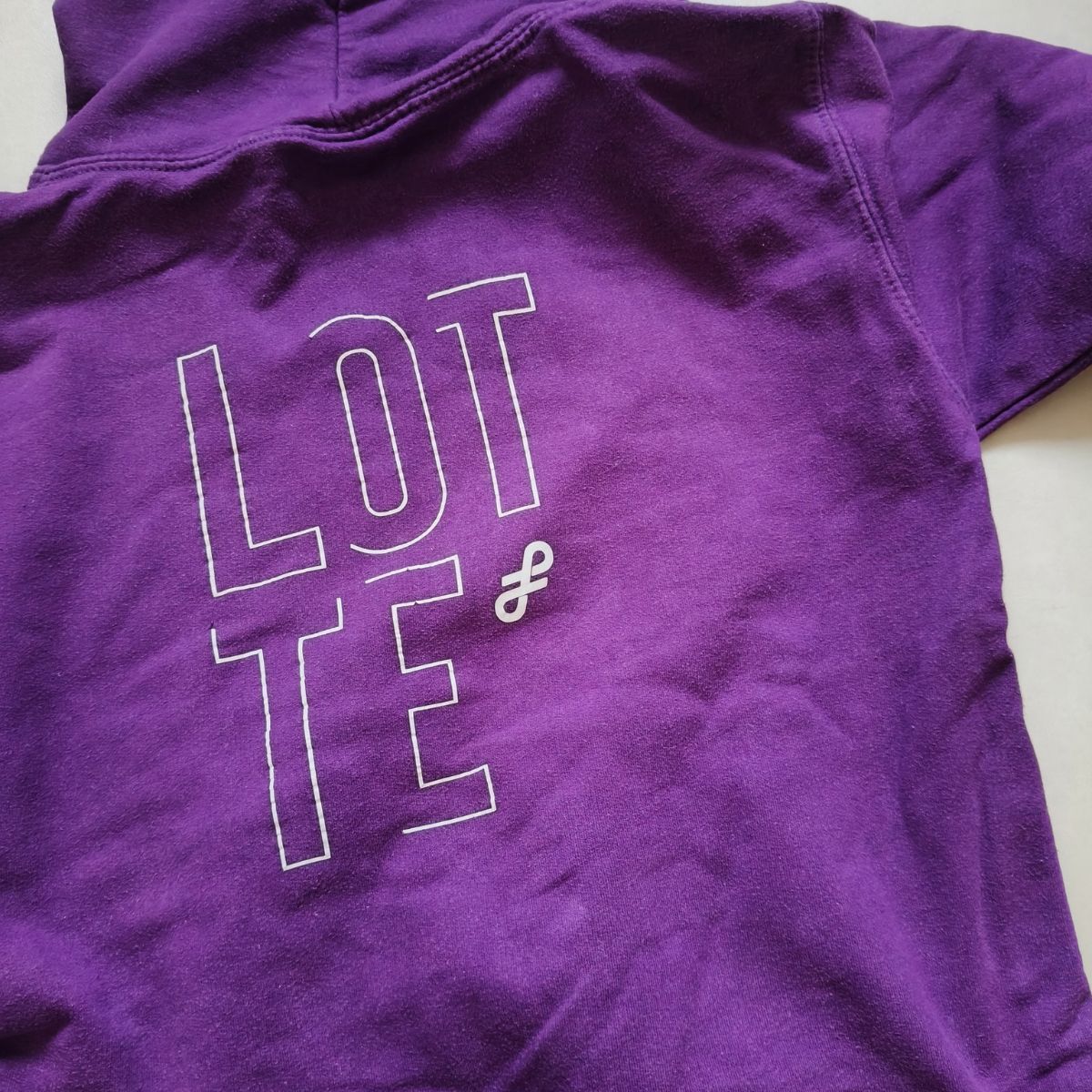 Paarse trui met op de achterzijde het logo van Flemming en de naam Lotte
