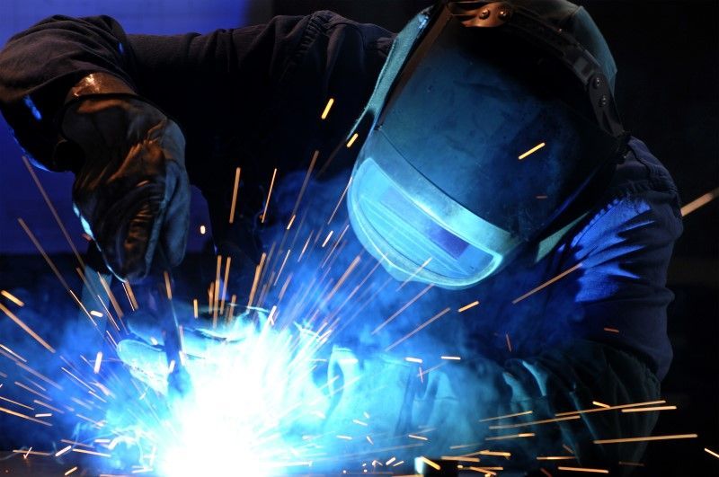A machine is cutting a piece of metal with sparks coming out of it.