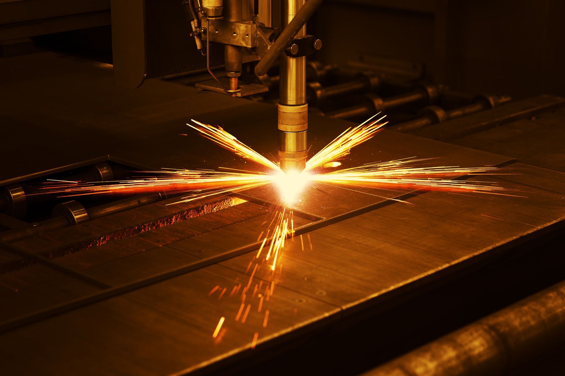 A machine is cutting a piece of metal with sparks coming out of it.