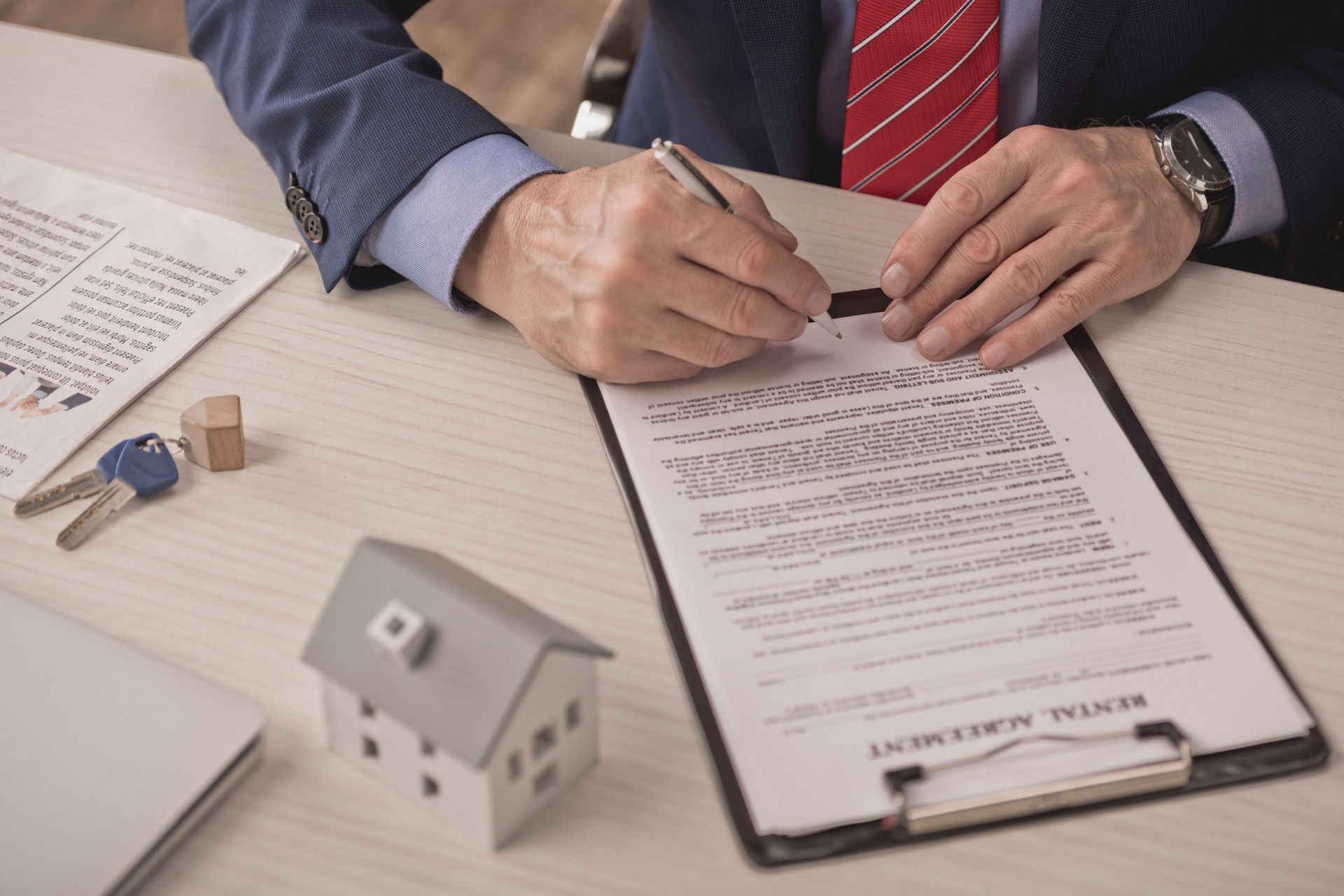 Un hombre con traje y corbata está firmando un contrato en un portapapeles.
