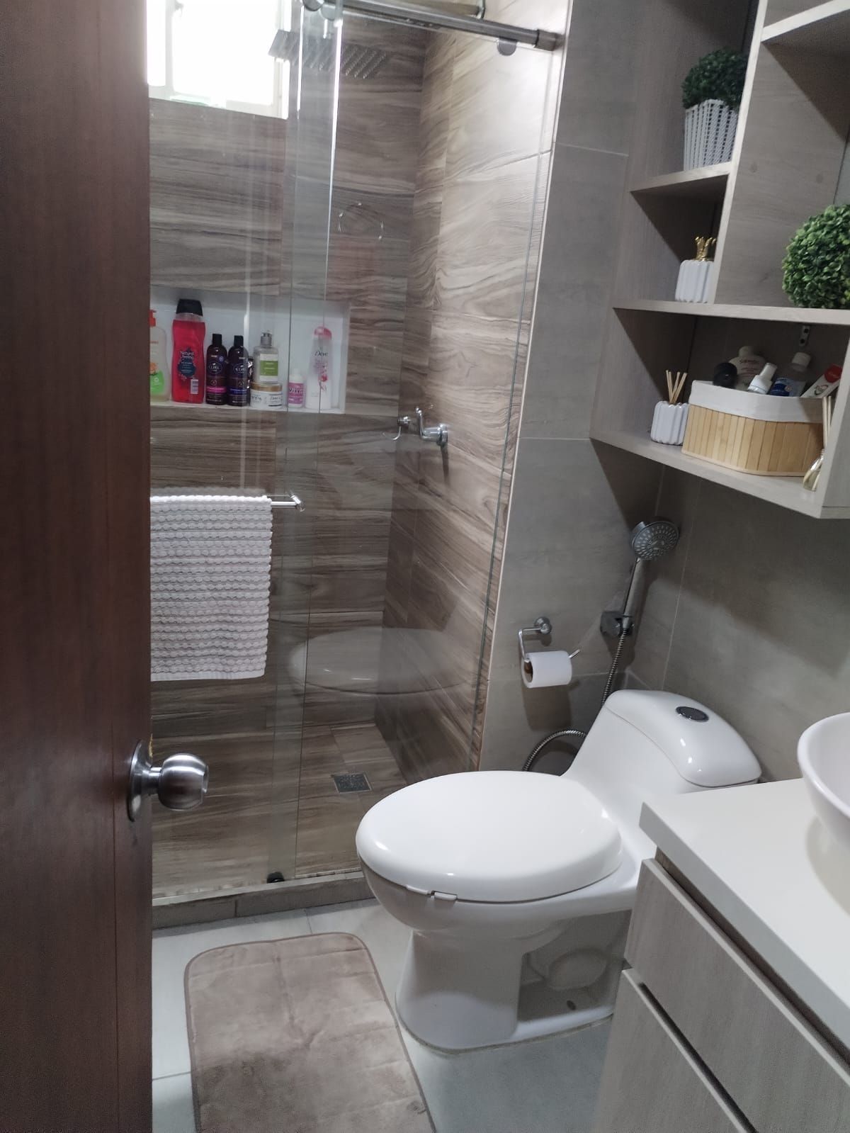Un baño con inodoro, lavabo y ducha.