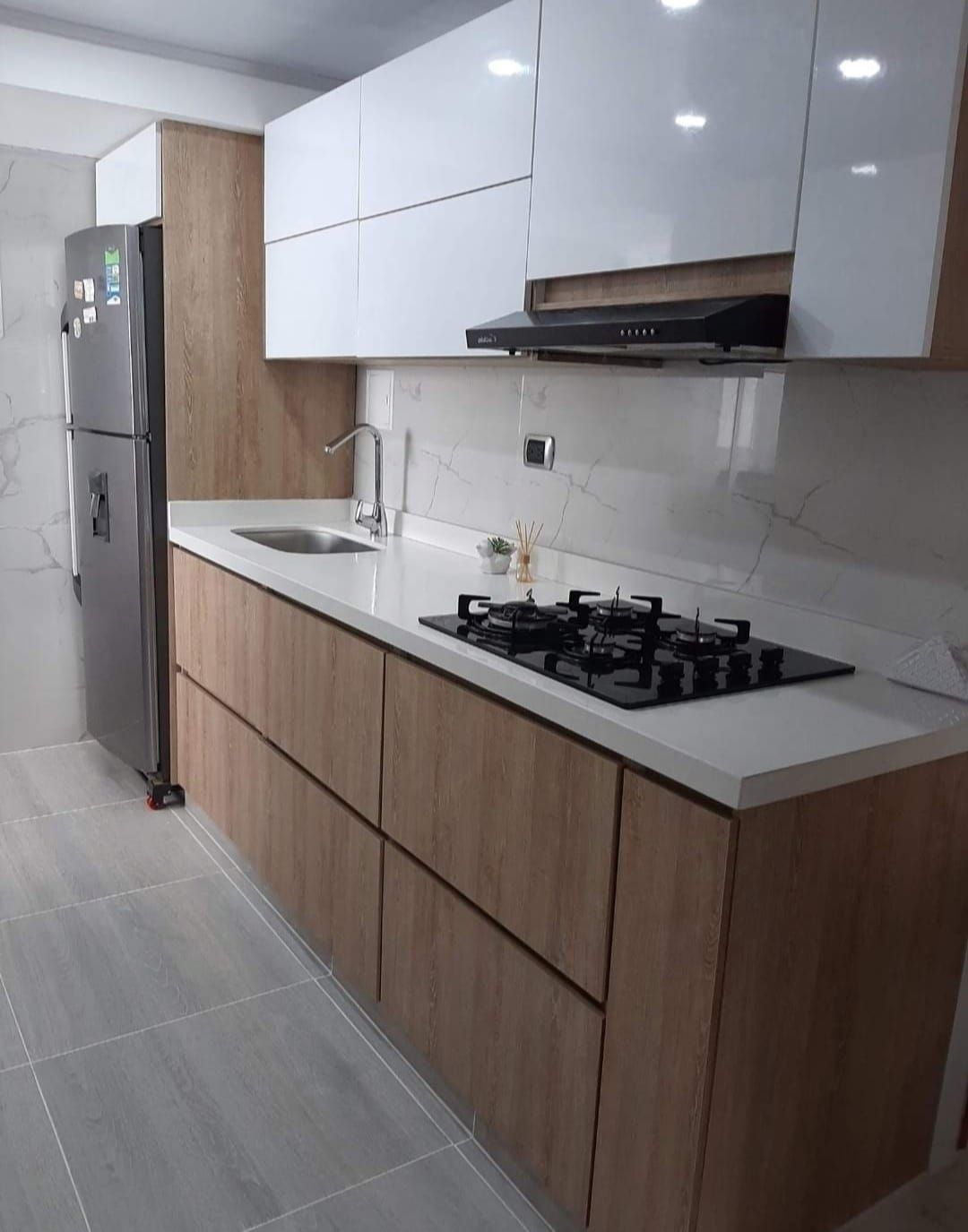 Una cocina con estufa, horno y refrigerador.