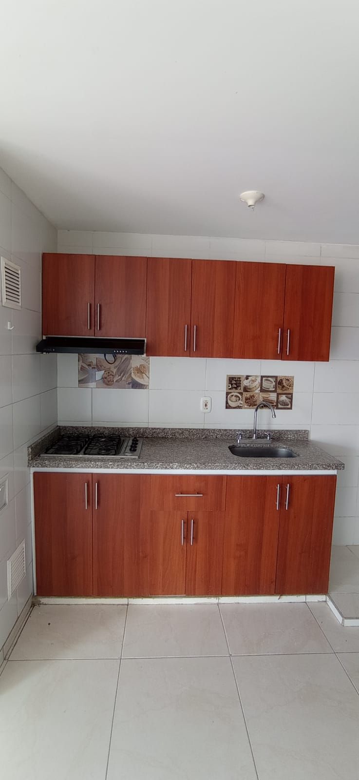 Una cocina con gabinetes de madera, un fregadero y una estufa.