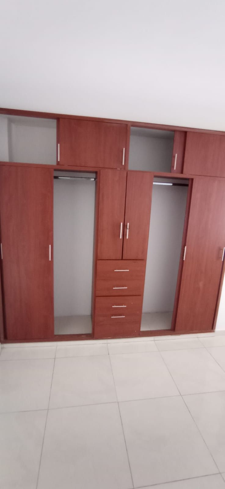 Un gran armario con puertas de madera y cajones en una habitación.