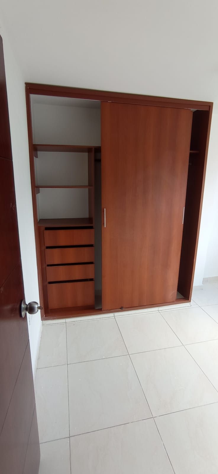Hay un armario con puertas correderas en la esquina de la habitación.