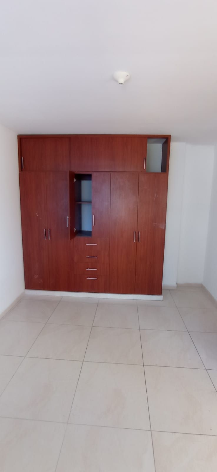 Una gran habitación vacía con muchos armarios y cajones de madera.