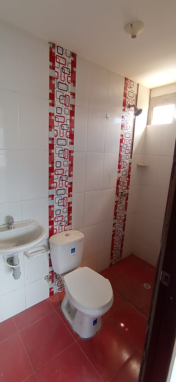 Un baño con inodoro, lavabo y ducha.