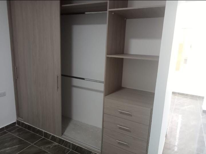 Un armario vacío con puertas correderas y cajones.