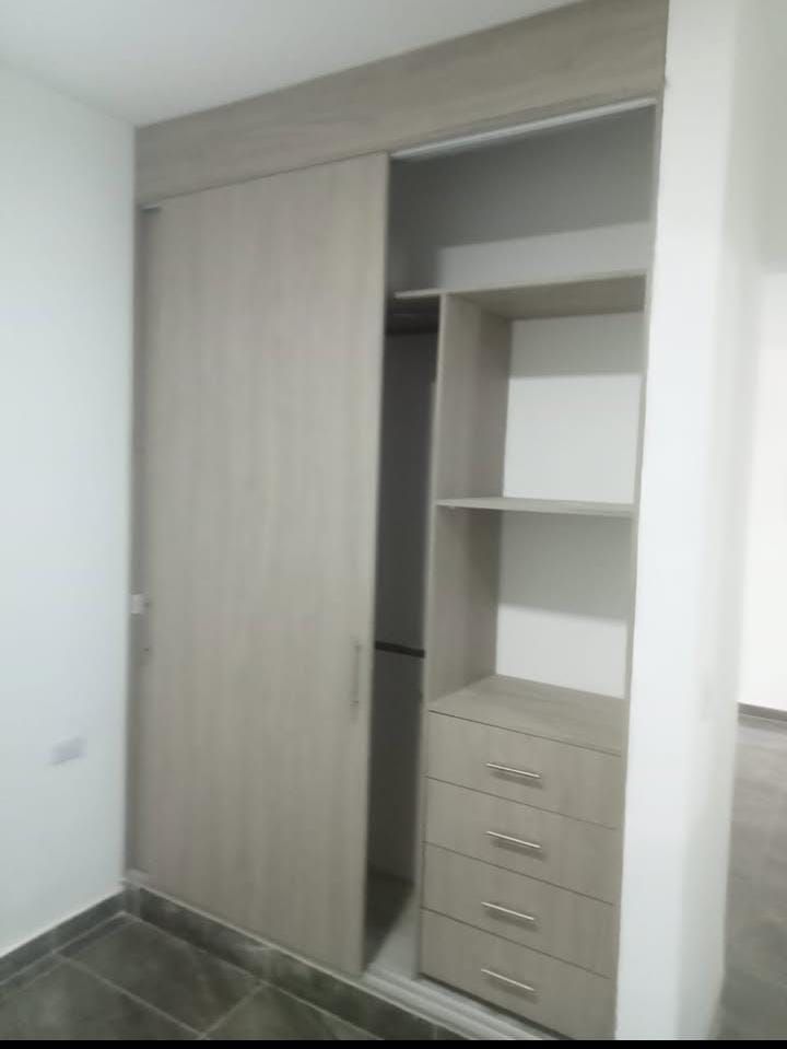 Un armario con puertas correderas y cajones en una habitación.