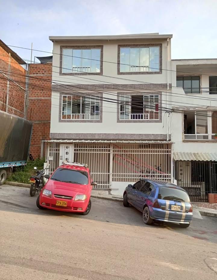 Un coche rojo está aparcado delante de un edificio.