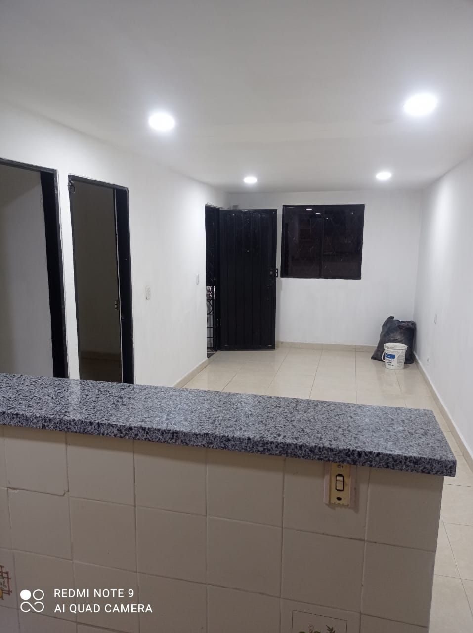 Una cocina con encimera de granito y puerta negra.