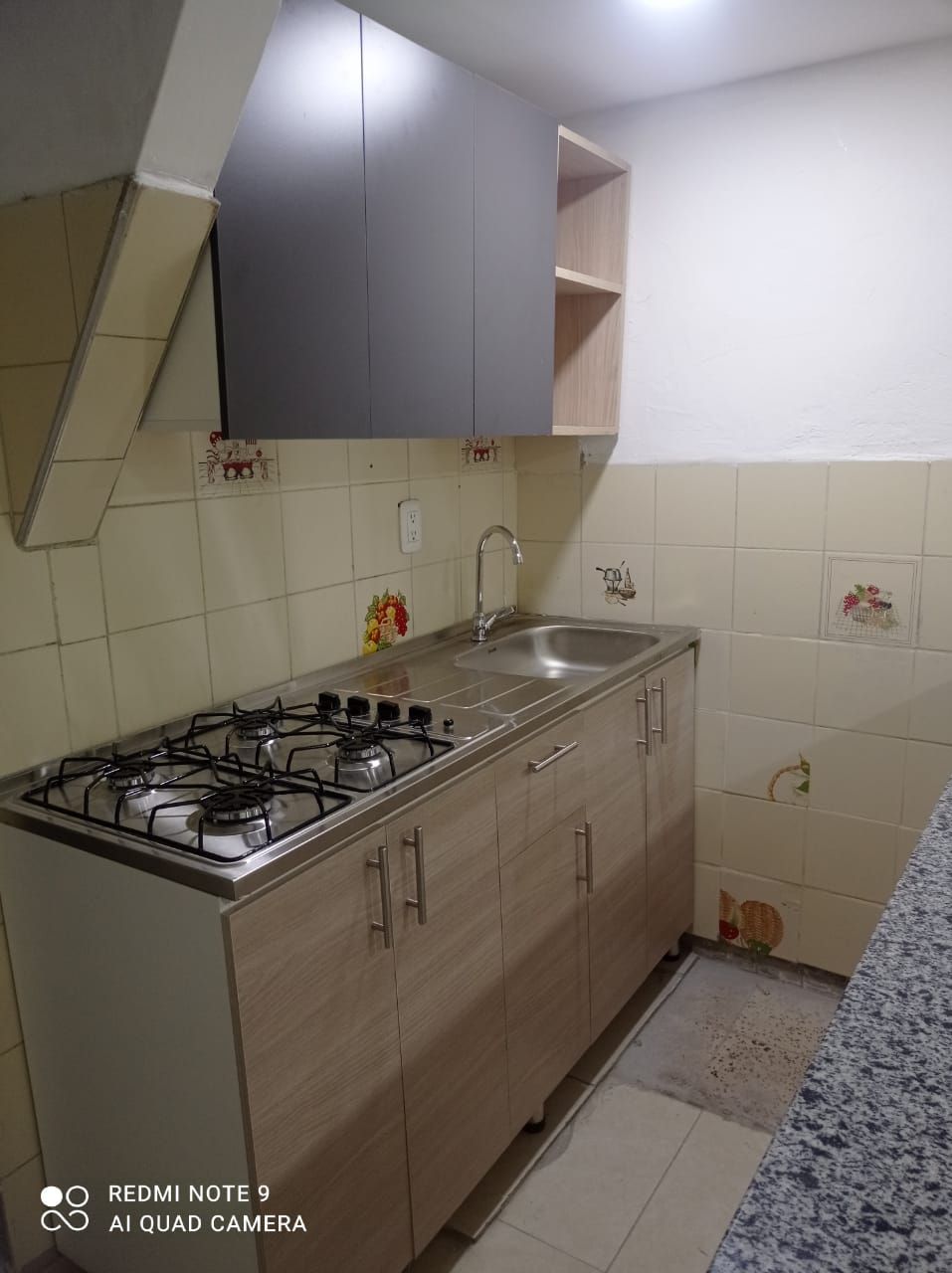 Una cocina con estufa, horno, fregadero y gabinetes.