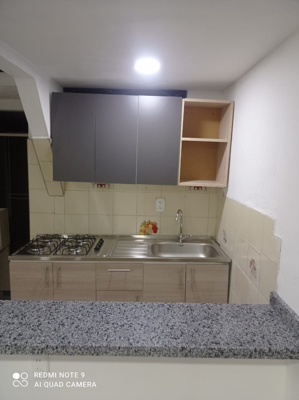 Una cocina con fregadero, estufa y gabinetes.