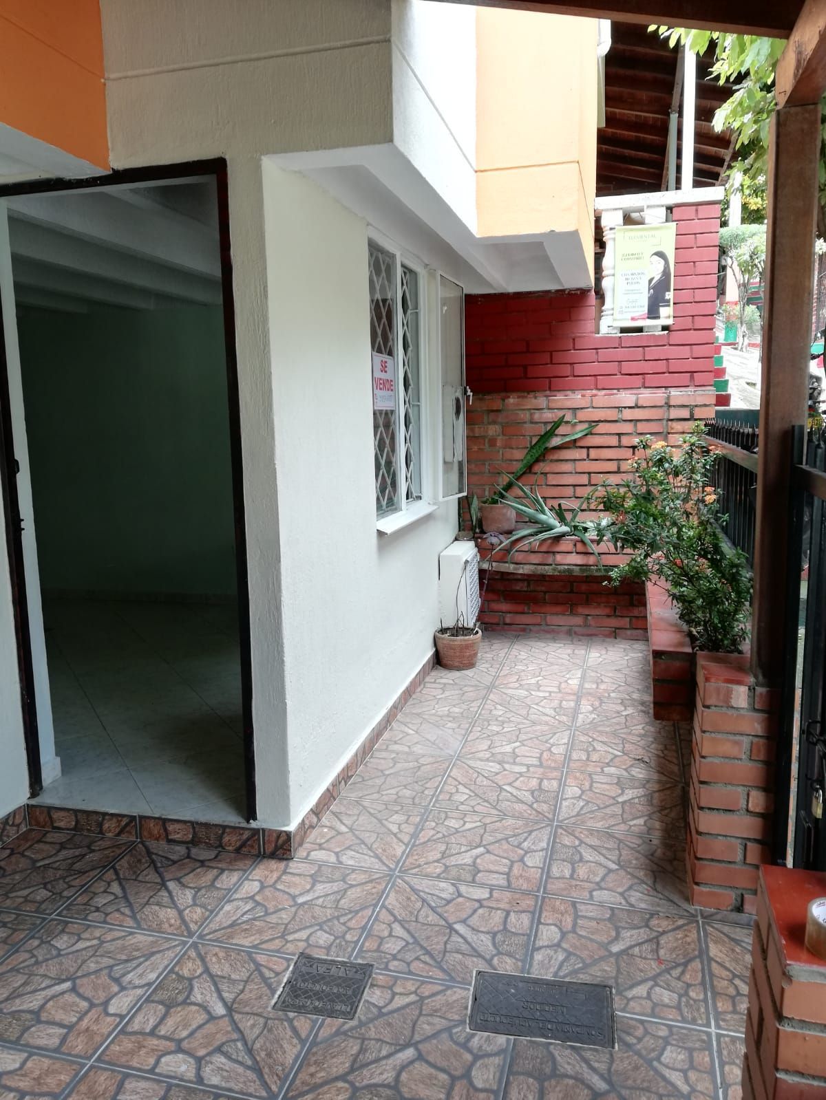Una habitación vacía con una pared de ladrillos y un suelo de baldosas.