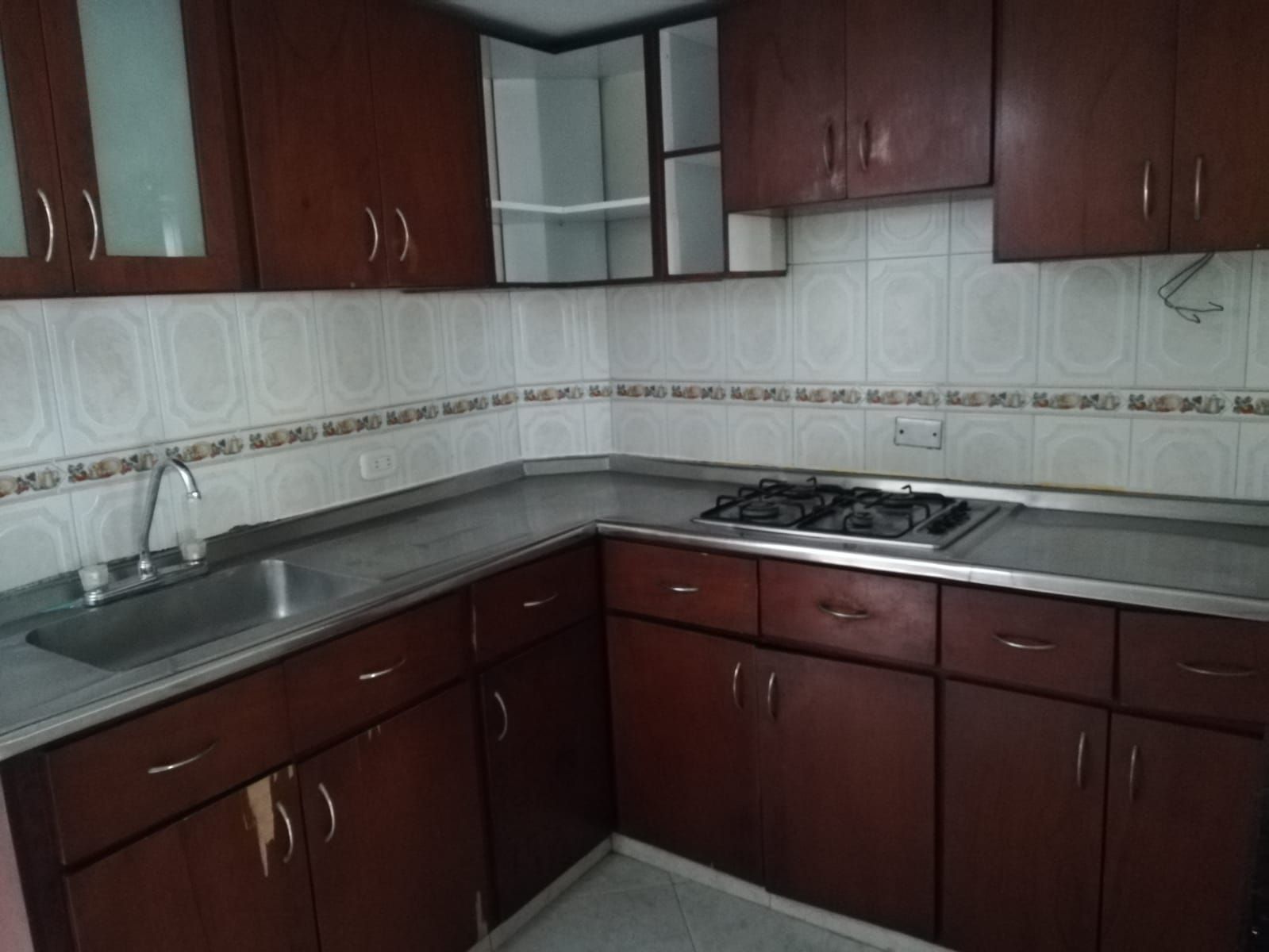 Una cocina con gabinetes de madera y un horno de estufa.