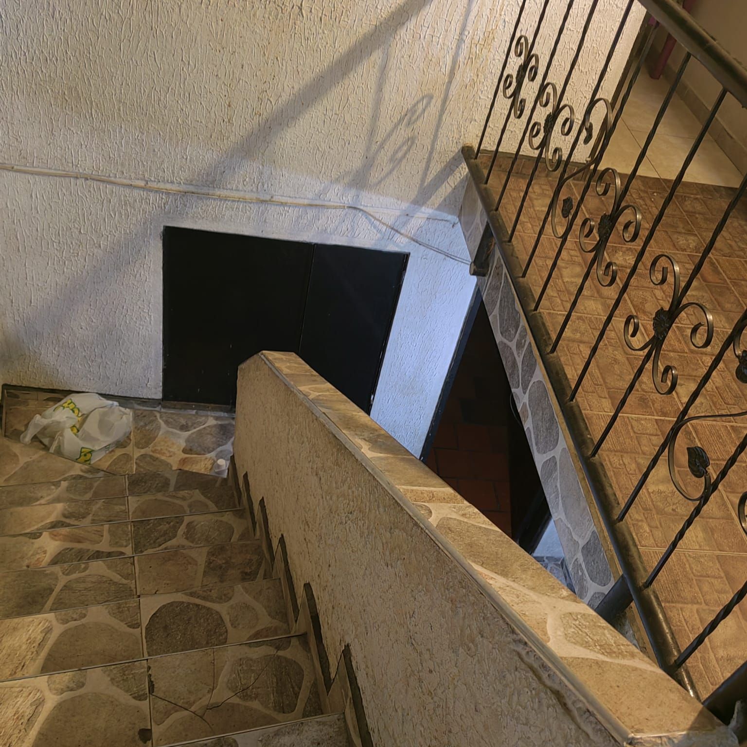 Un conjunto de escaleras de piedra con barandilla de hierro forjado.