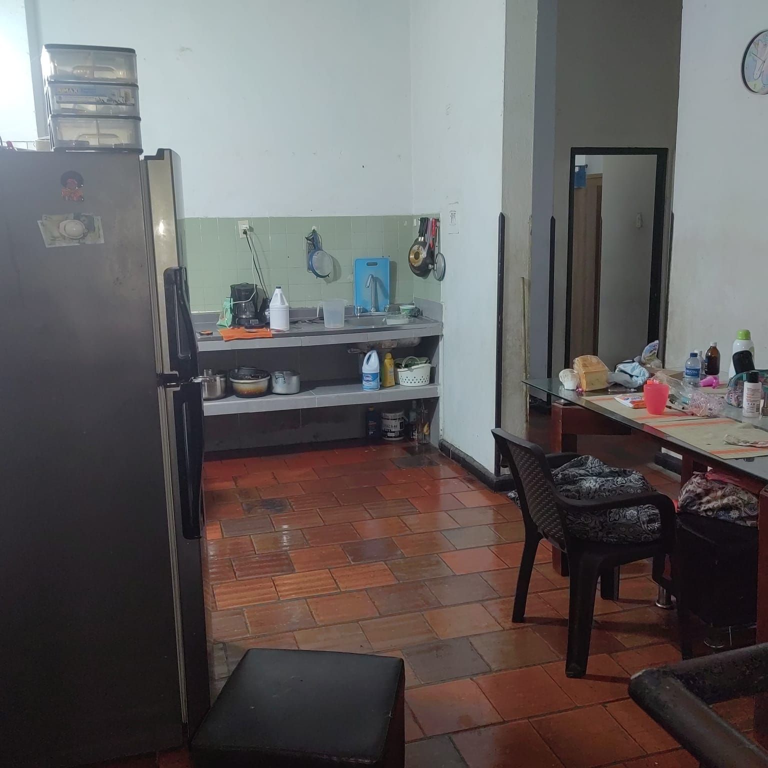 Una cocina con un refrigerador y una silla dentro.