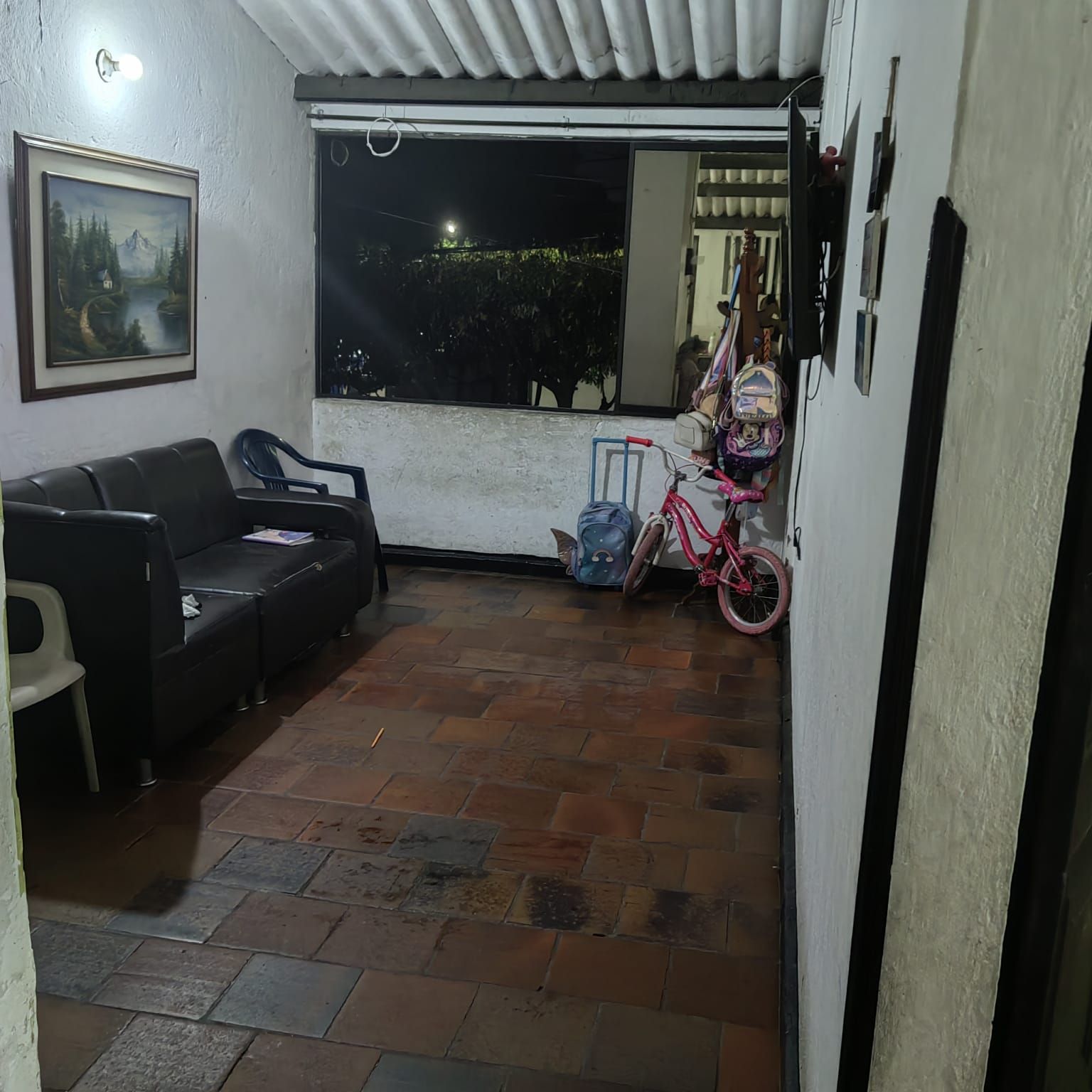 Una sala de estar con un sofá, una silla y una bicicleta.