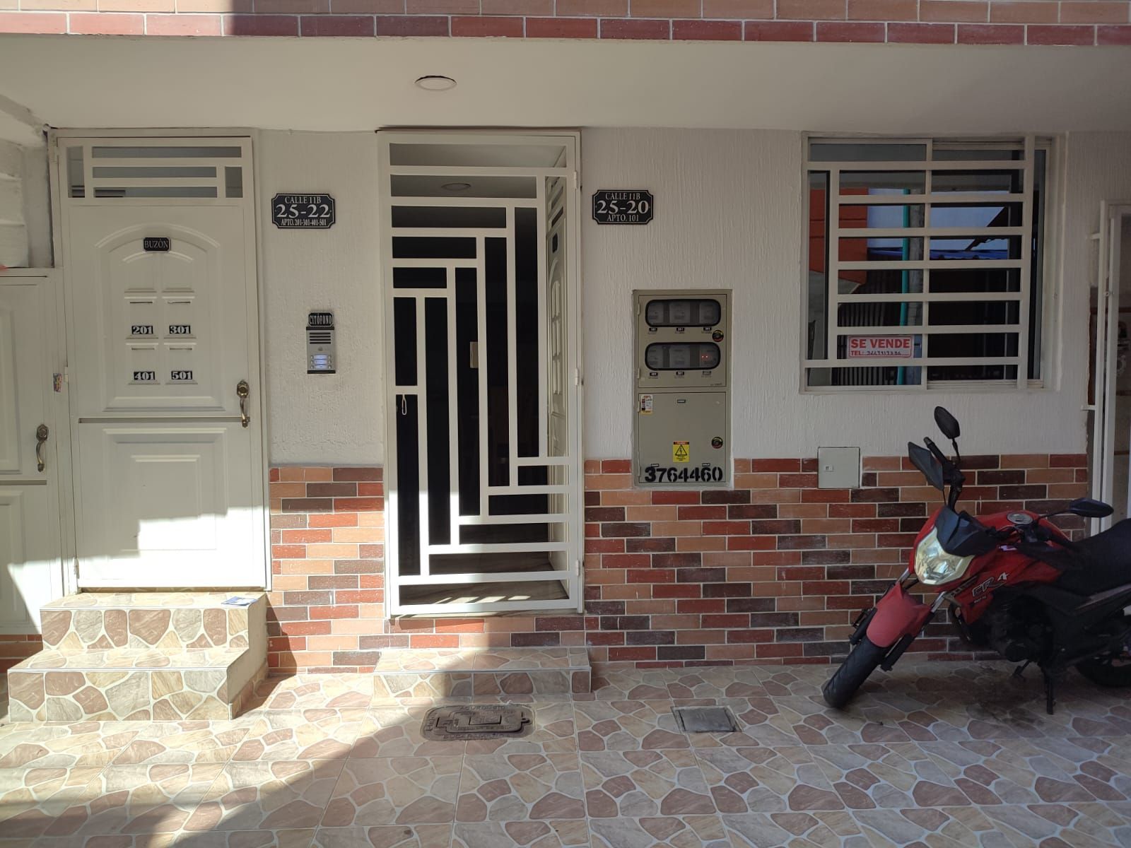 Una motocicleta roja está estacionada frente a un edificio de ladrillos.