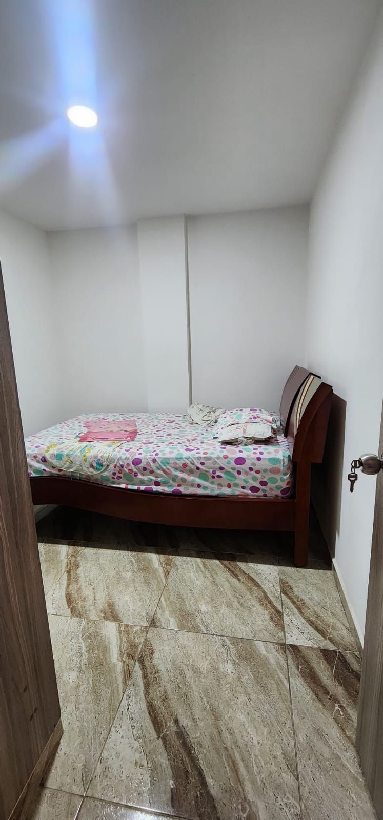 Un dormitorio con una cama y suelo de mármol.