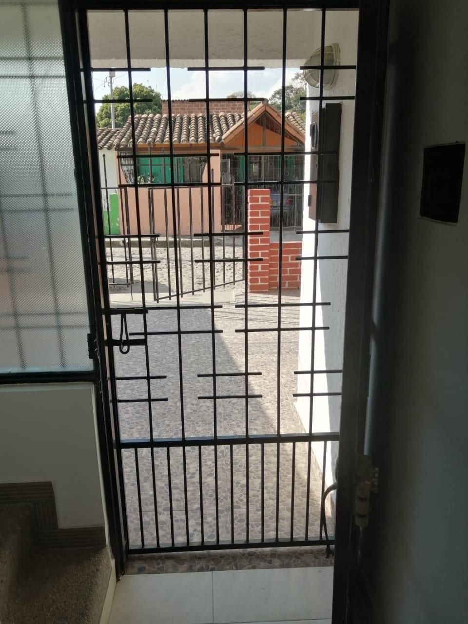 Una puerta con rejas que conduce a un edificio de ladrillo.