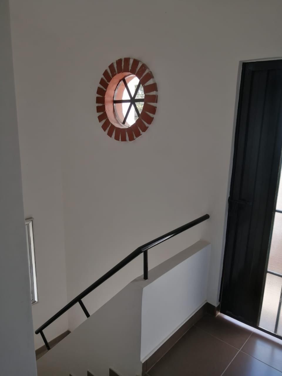 Una escalera con una ventana de ladrillo en la pared.