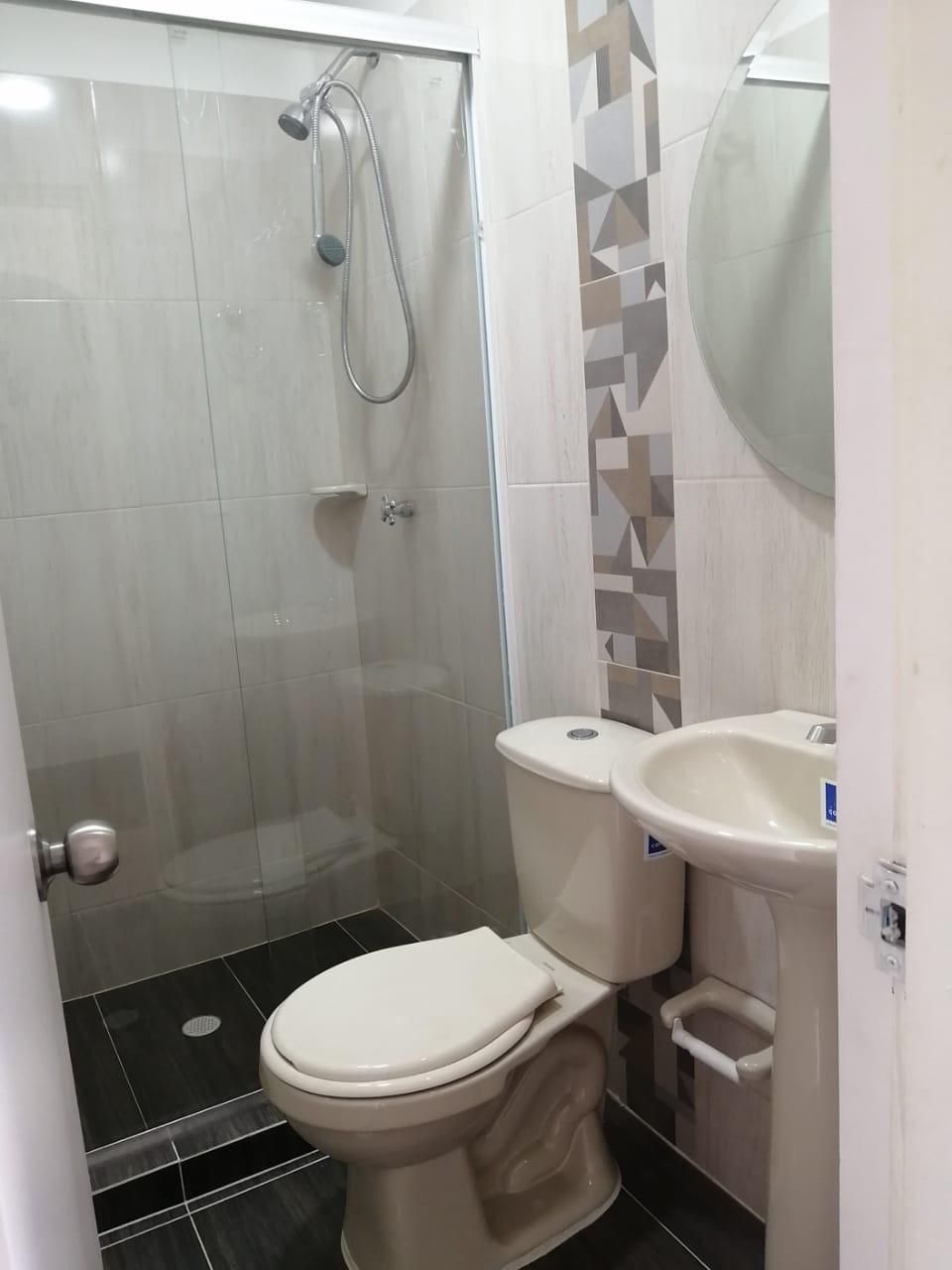 Un baño con inodoro, lavabo y ducha.