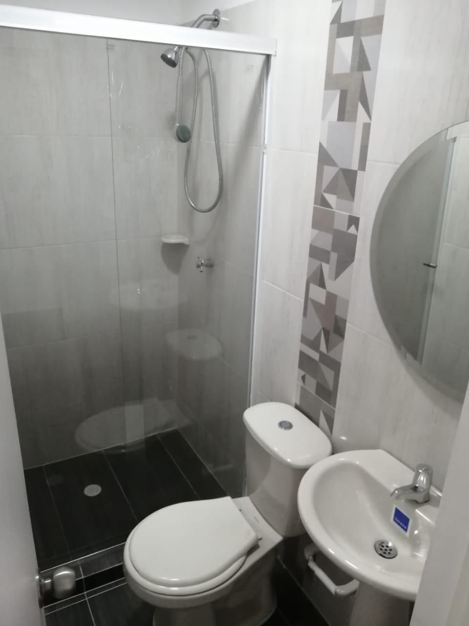 Un baño con inodoro, lavabo y ducha.