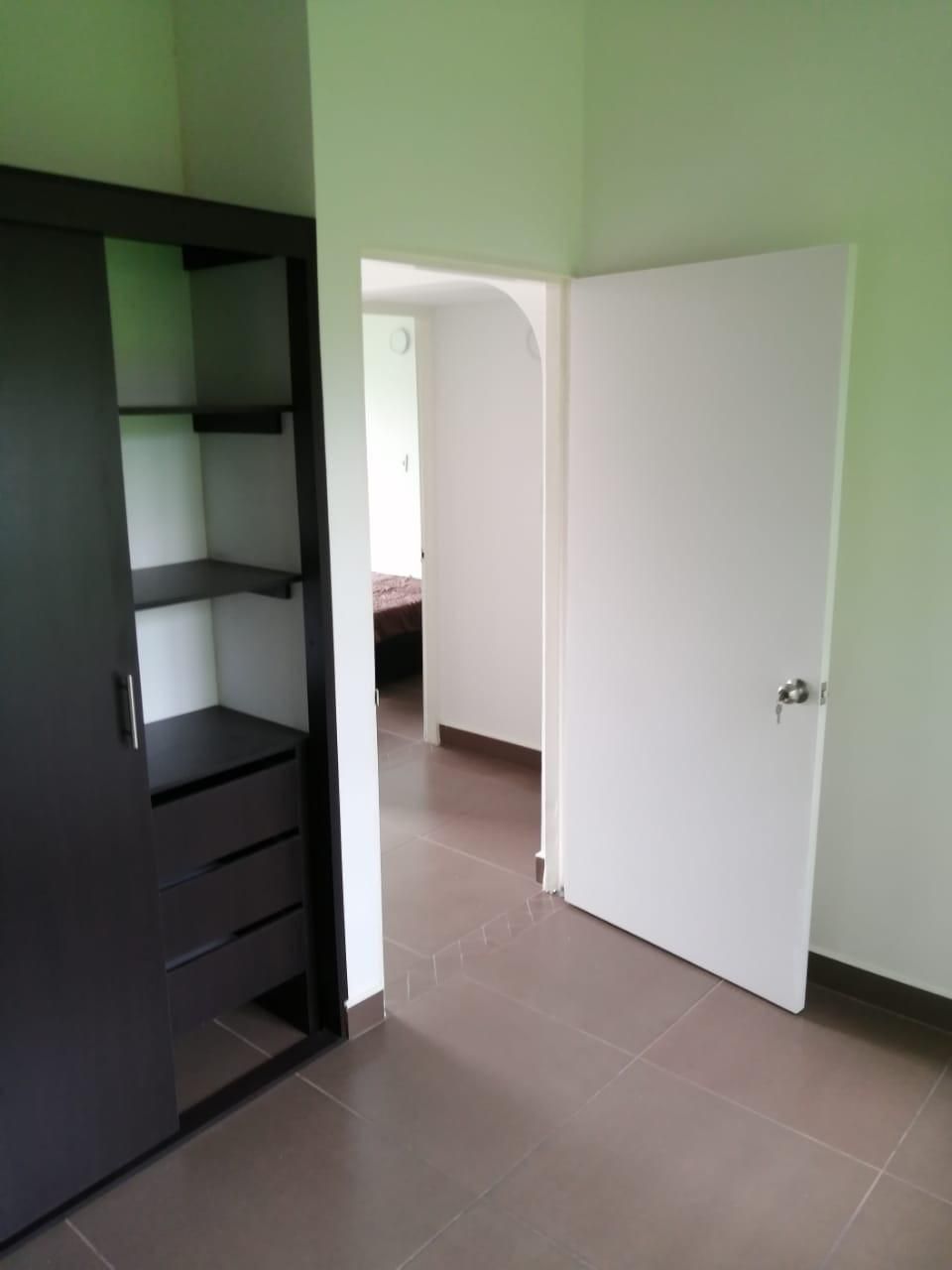 Una habitación con un armario y una puerta que da a otra habitación.
