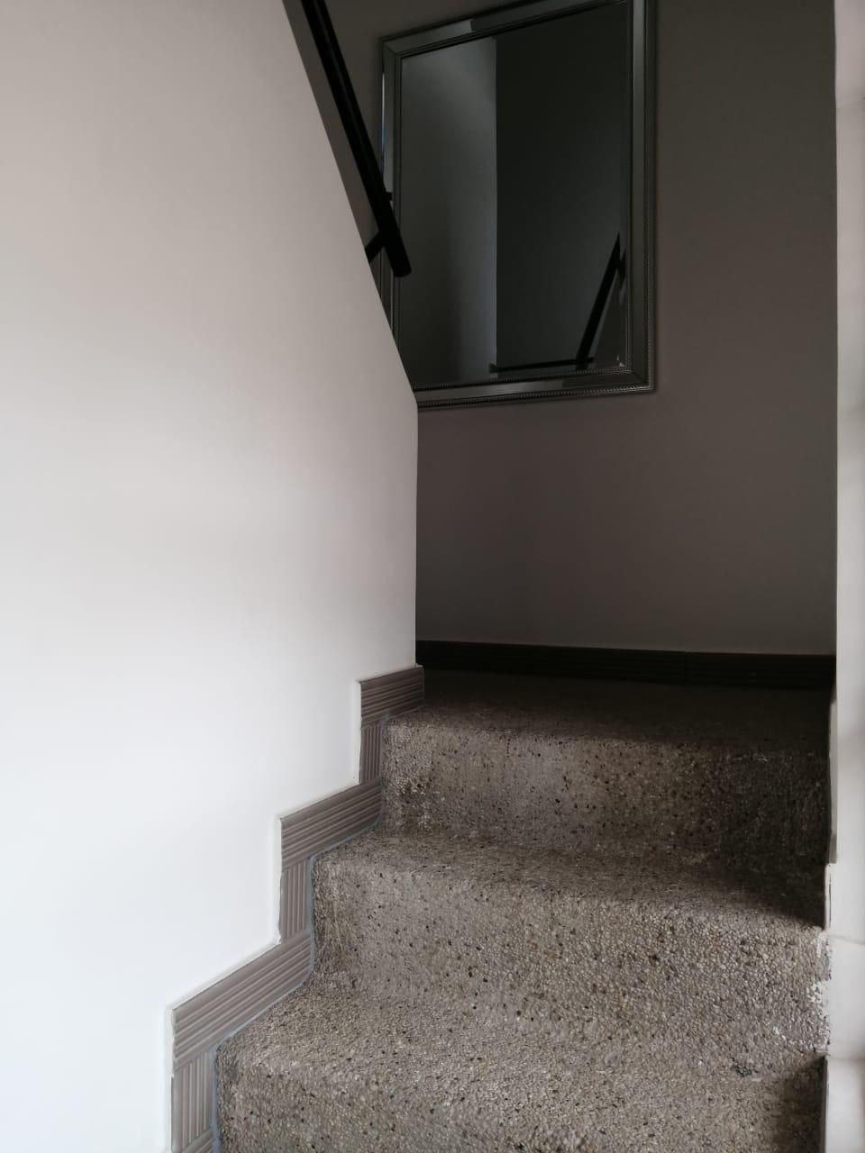 Un conjunto de escaleras que conducen a una ventana de un edificio.