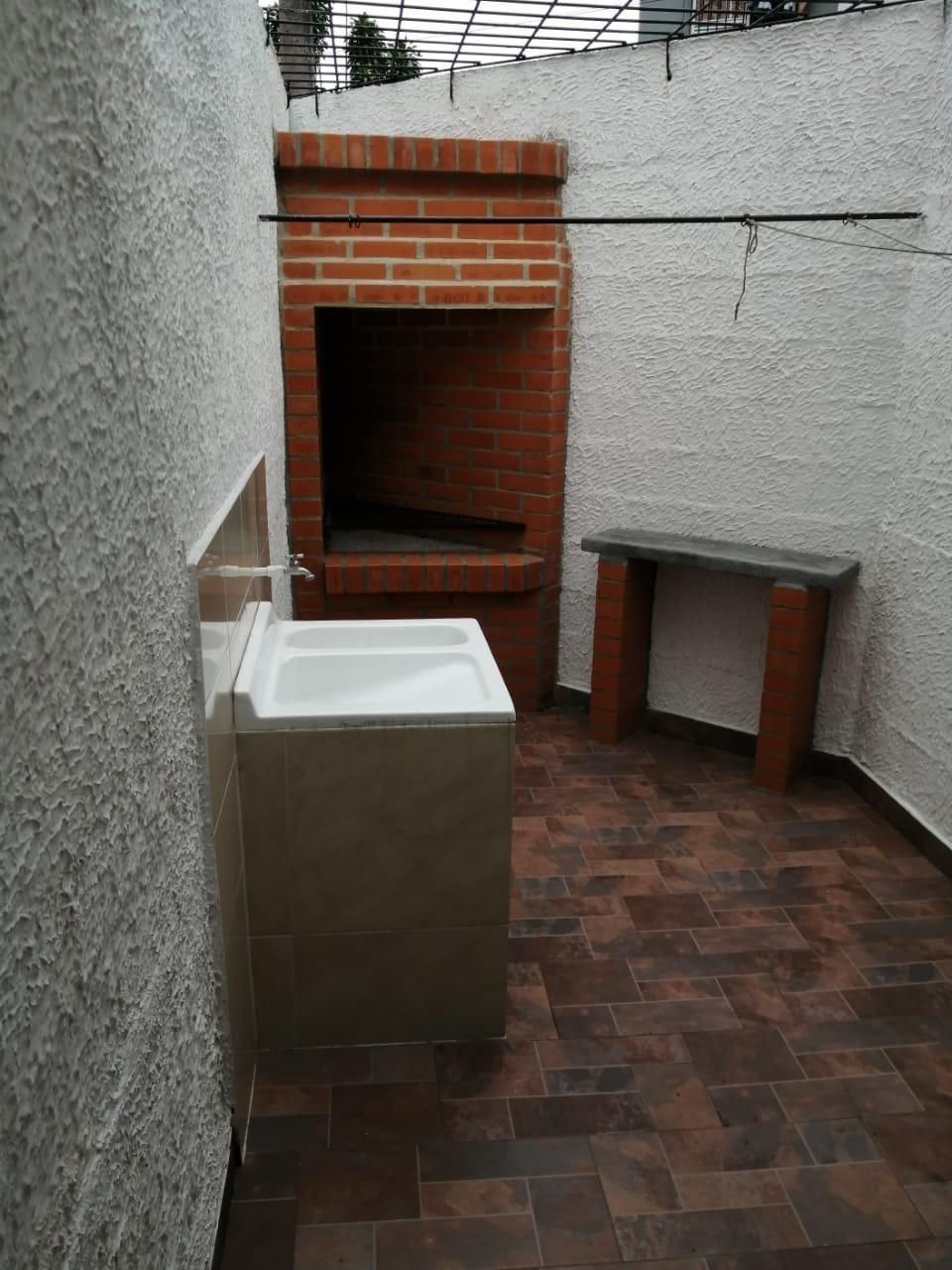 Una pared de ladrillos con un lavabo delante.